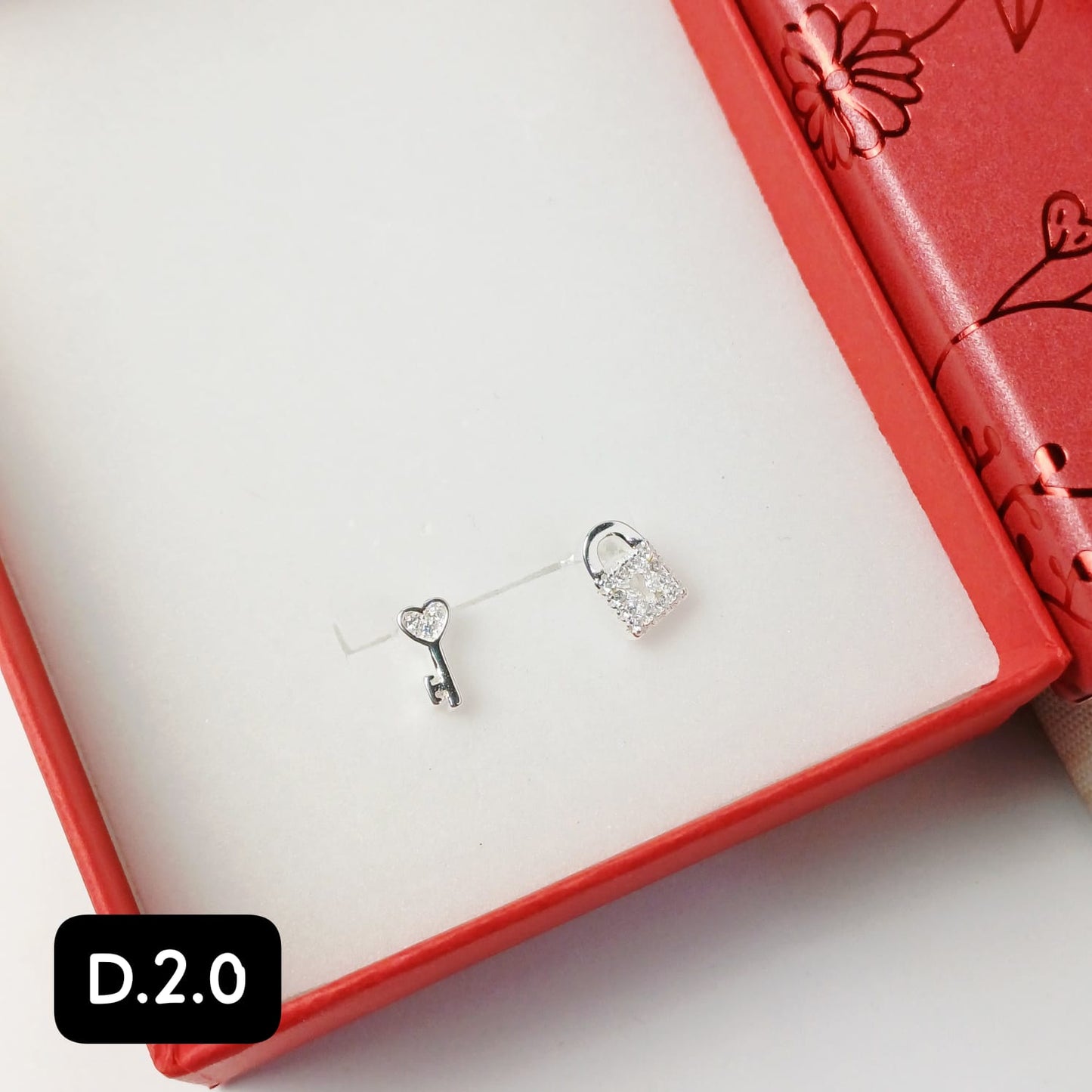 Arete pegado de llave y candado